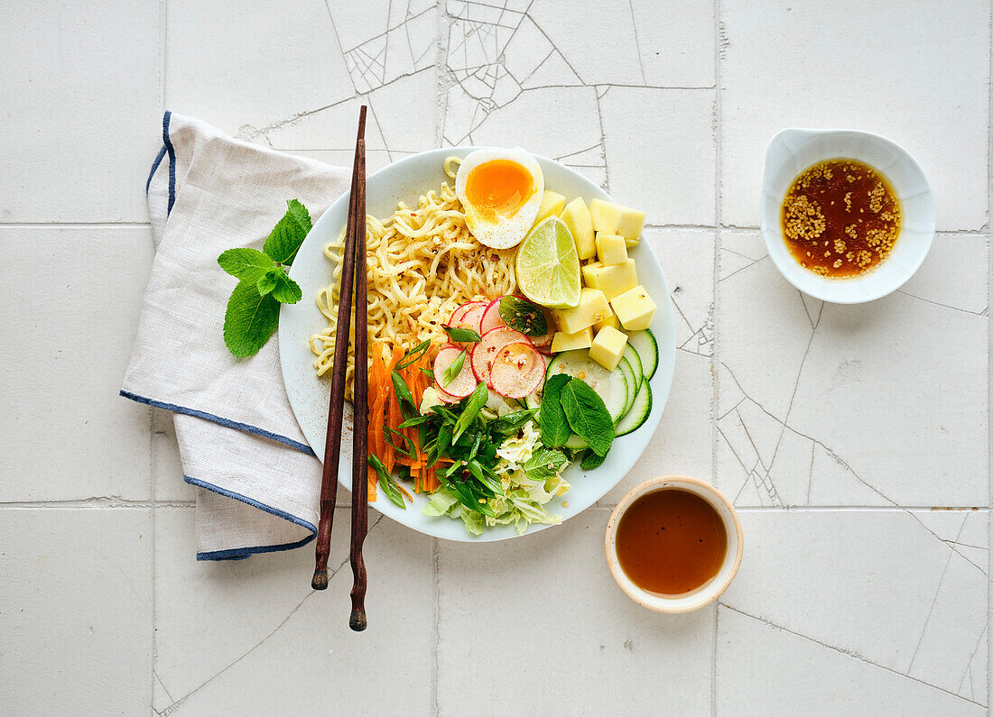Salad ramen - vegetarian dish with egg noodles, mango, lime and vegetables. Healthy pan-Asian cuisine
