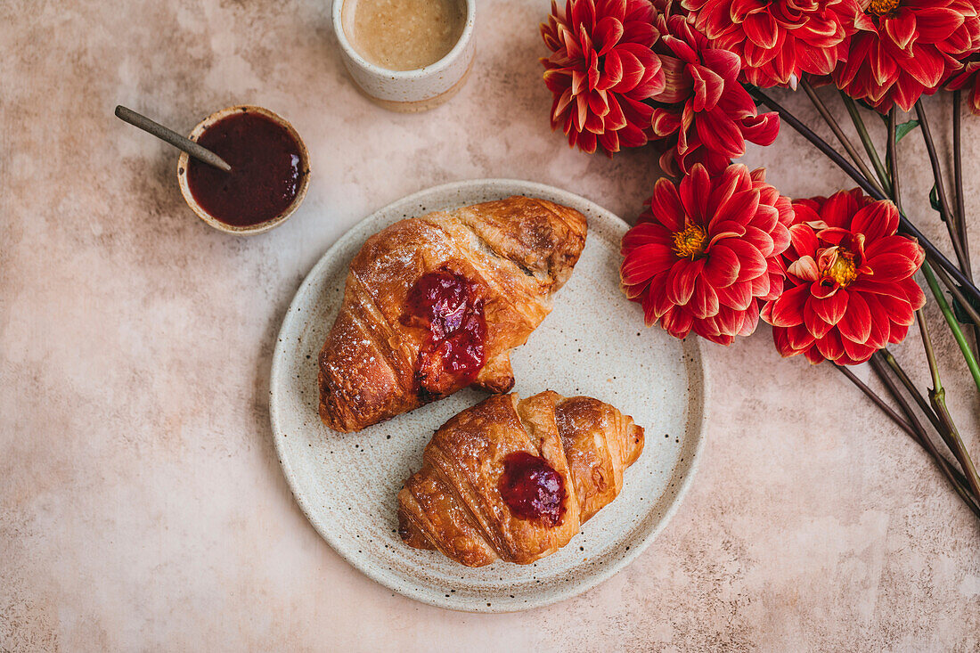 Croissants mit Erdbeermarmelade auf einem Keramikteller