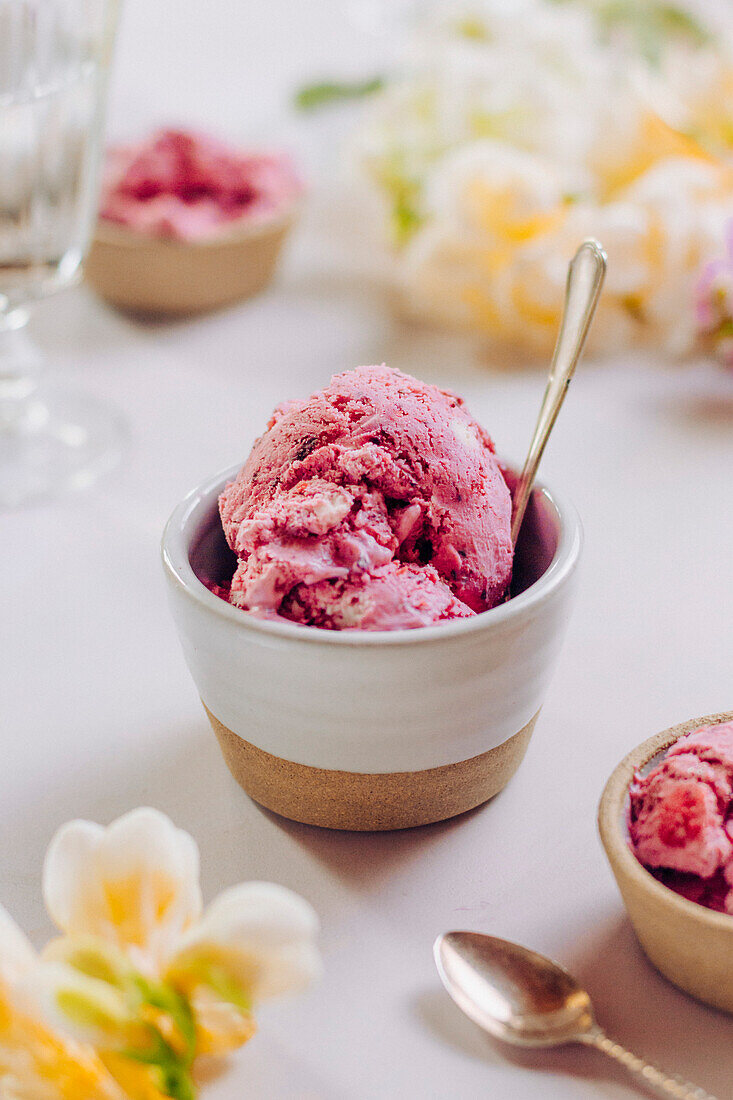 Bowl of pink berry ice cream with flowers