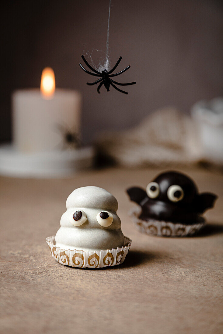 Geister- und Fledermaus-Bonbons für Halloween; mit Keksboden, Dulce de Leche-Füllung und Schokoladenüberzug.