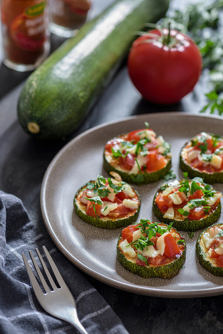Baked zucchini with tomatoes and cheese on a plate.