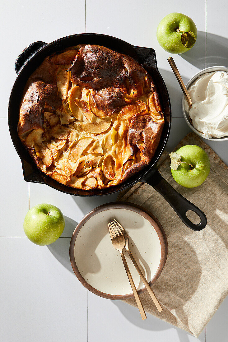 German apple pancake with pan and plates