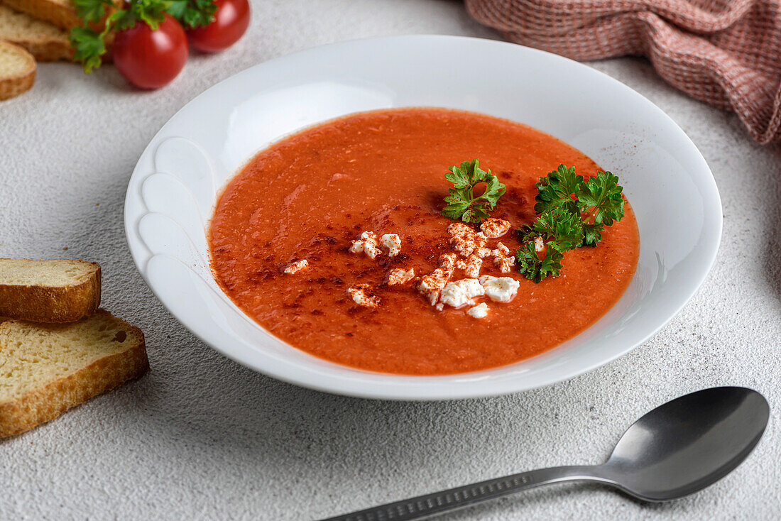 Tomato cream soup decorated with cheese and parsley.