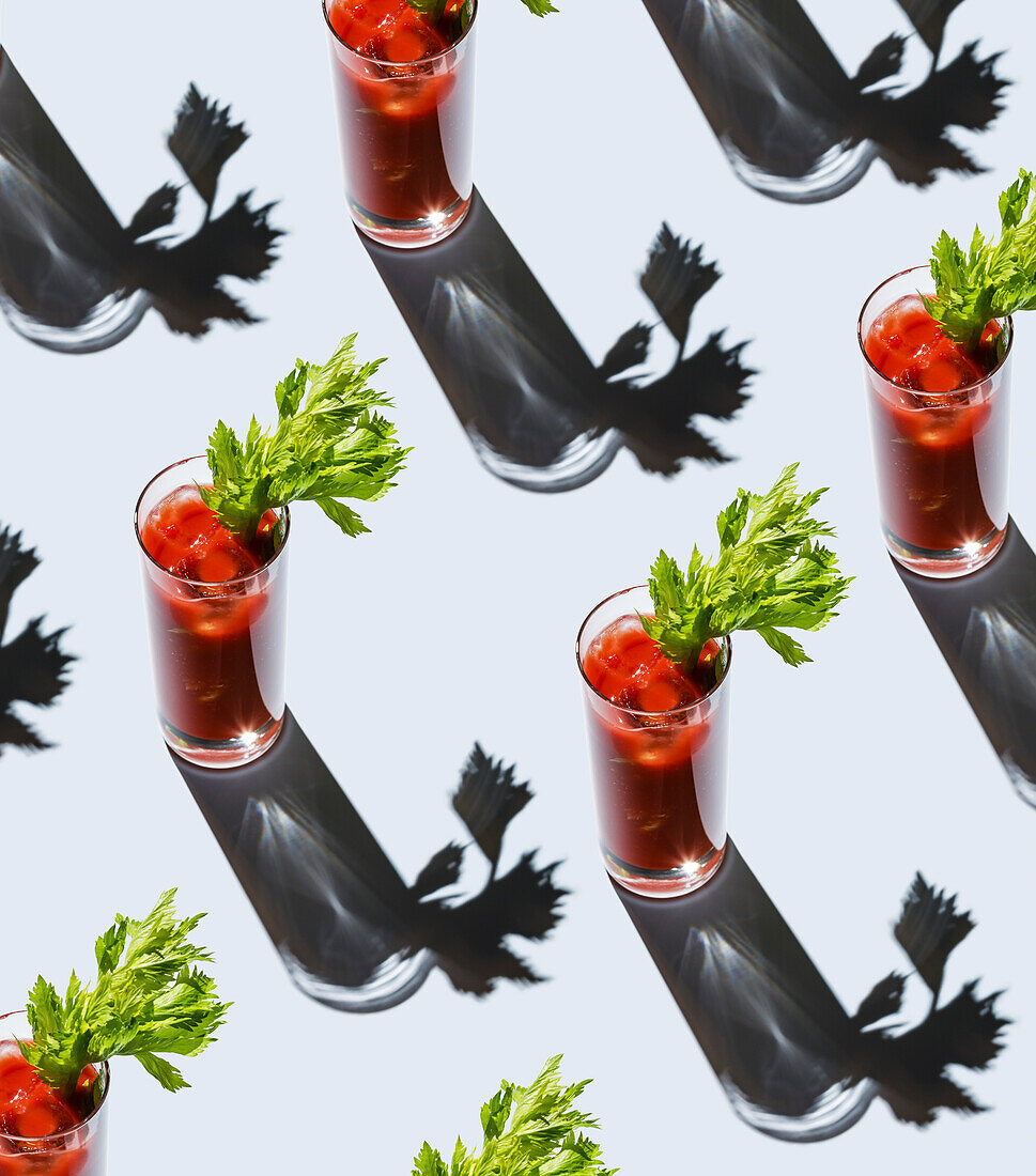 Bloody Mary cocktail with ice and celery on gray background Pattern