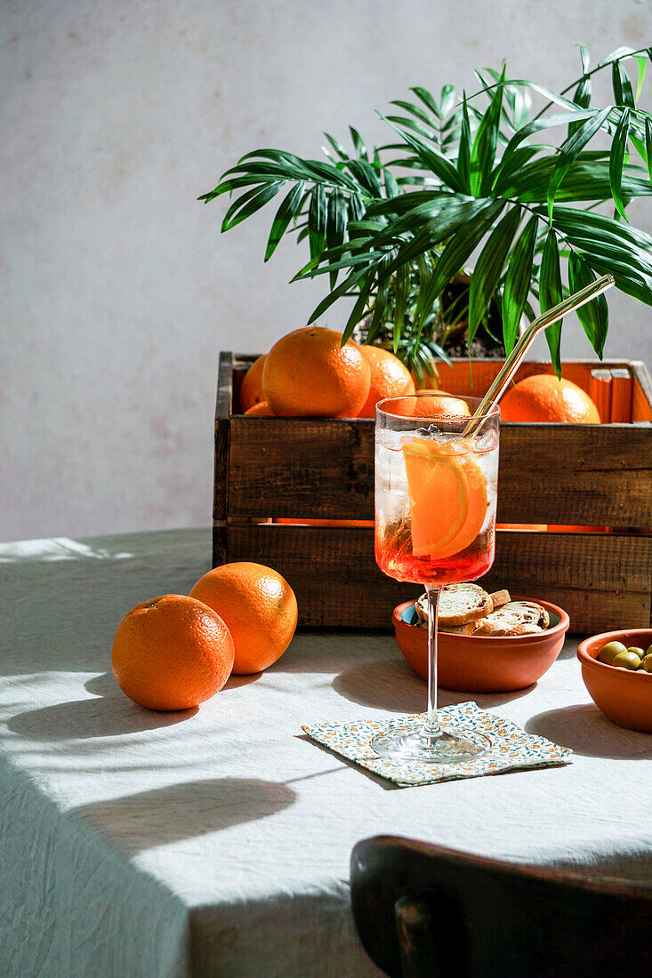 Aperol Spritz, cocktail, on a linen tablecloth, shade, hard sunlight, summer drink in a glass