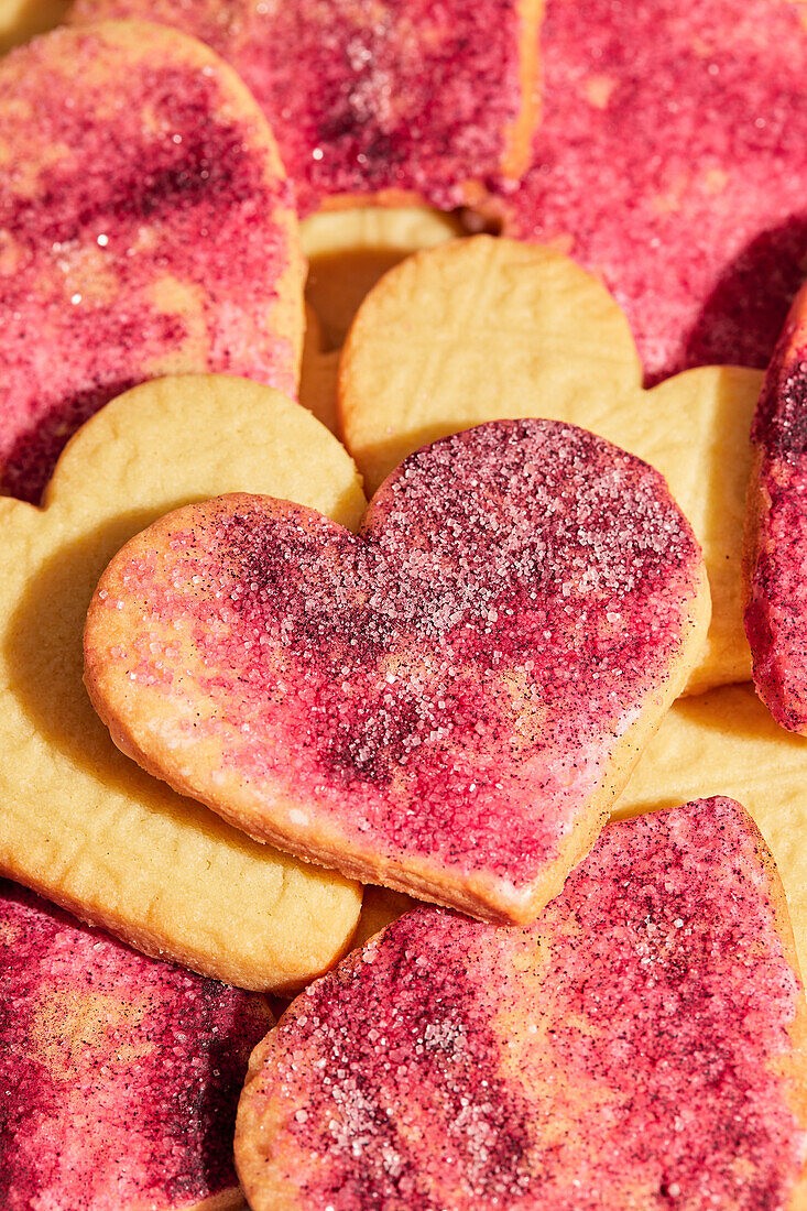 Stamped Heart Cut-Out Cookies with Pink Sugar on a Pink Marble Background
