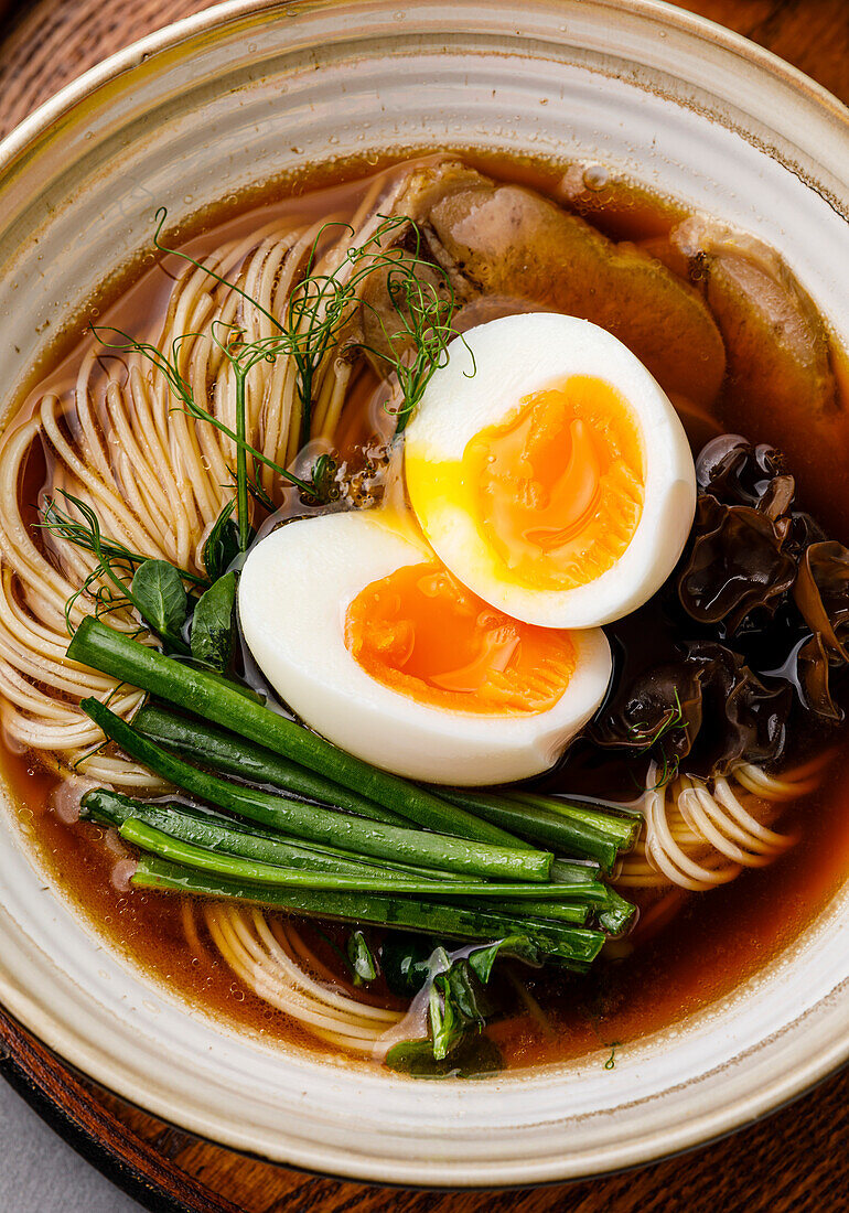 Ramen, Asian noodles in broth with beef tongue, mushrooms and eggs in a bowl