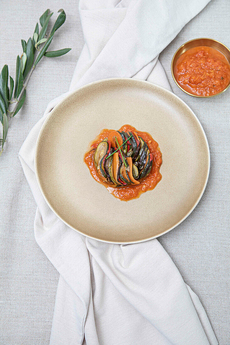 A modern take on ratatouille or mixed steamed vegetables, served on a ceramic plate