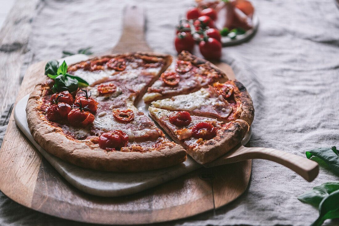 Schinken-Mozzarella-Pizza auf einem Schneidebrett