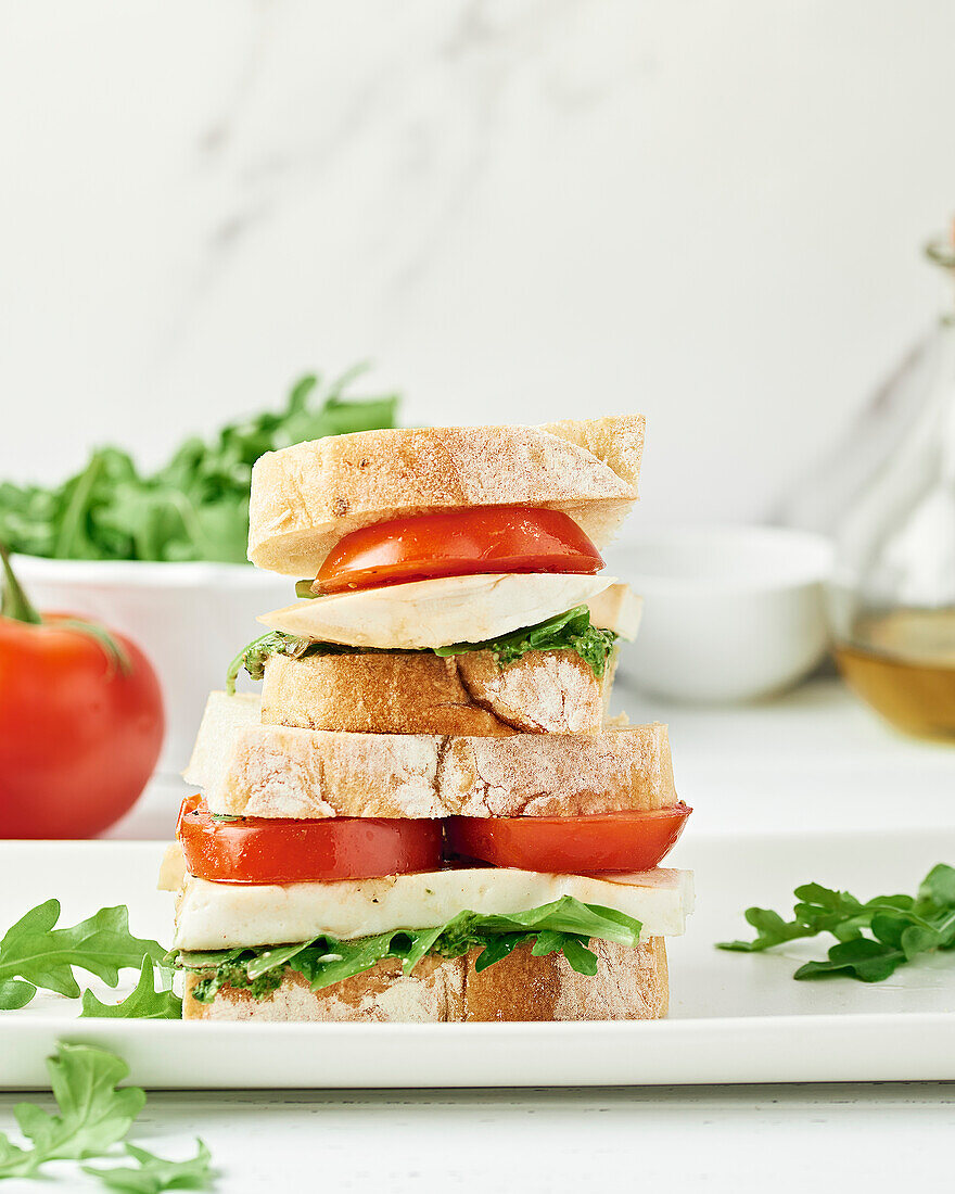 Veganes Caprese-Sandwich auf einem weißen Teller