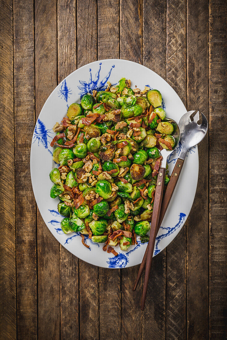 Sautéed Brussels sprouts and bacon on a white and blue plate