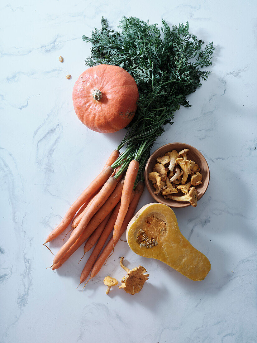 Draufsicht mit herbstlich-orangem Gemüse. Karotten, Kürbis, Butternusskürbis