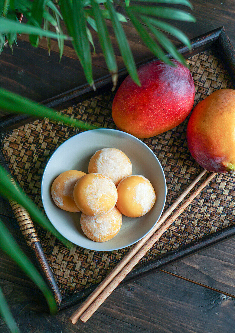 Japanese mango mochi tartlets with ice cream on a classic Asian wooden tray