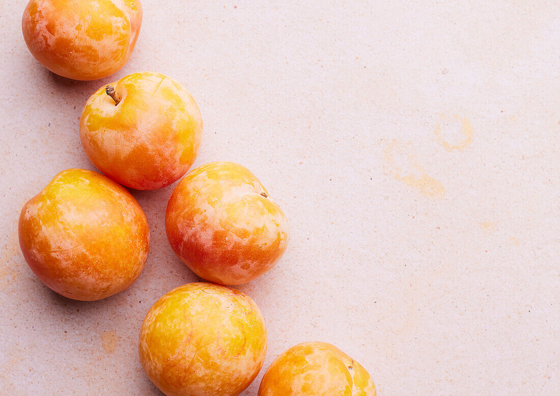 Yellow plums on a light pink background