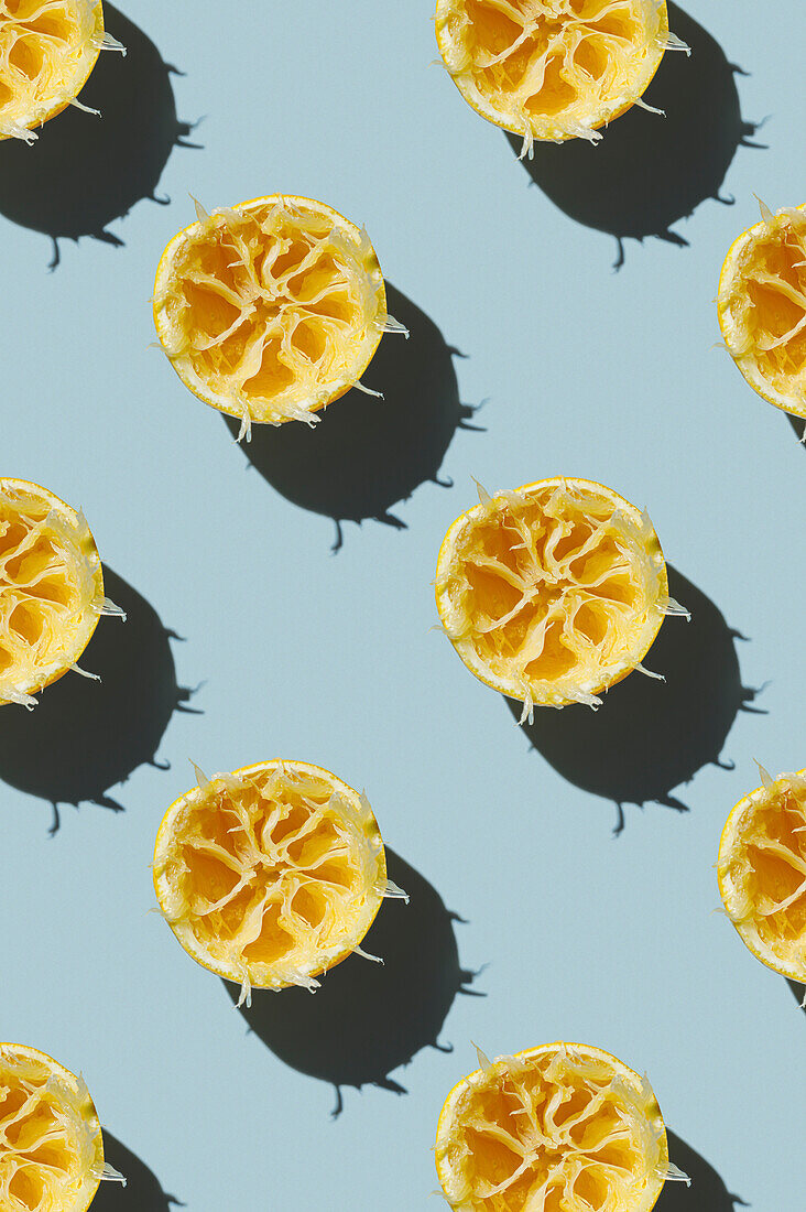 Vertical Pattern of Squeezed juicy Lemon after making fresh drink smoothie on green background flatlay food