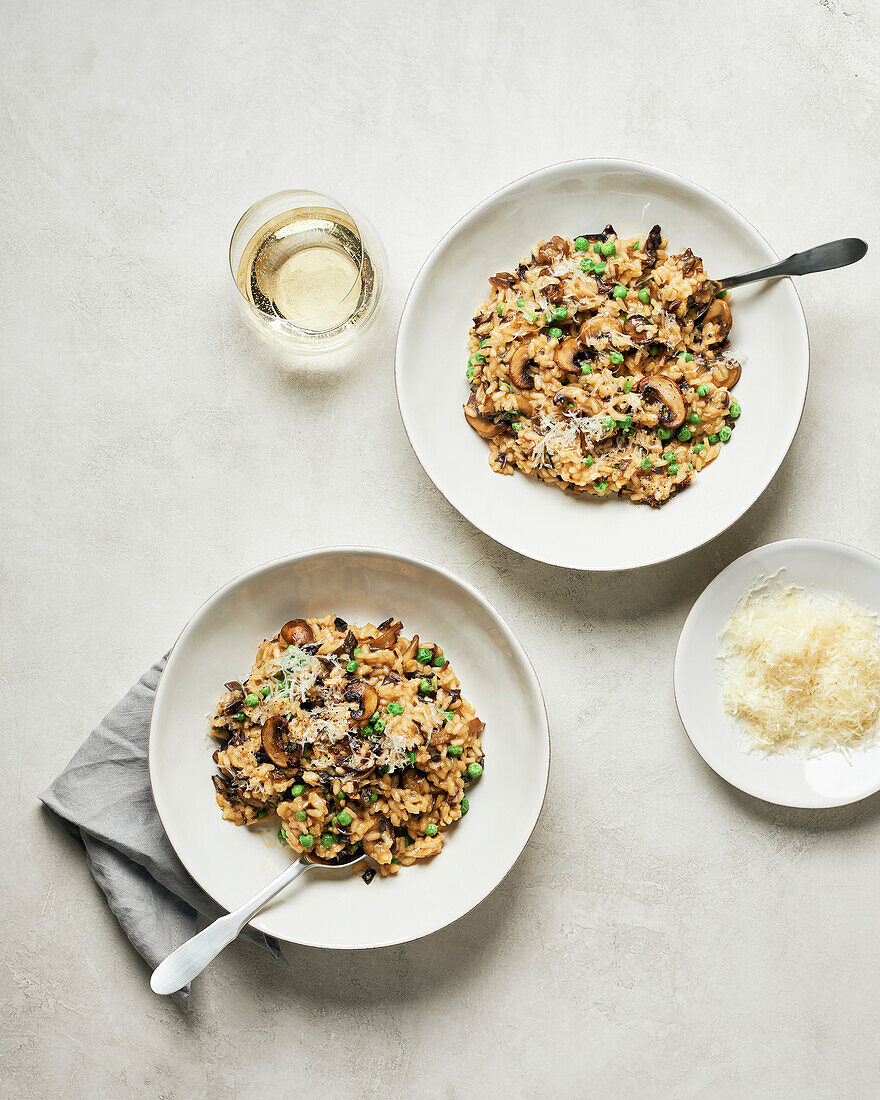 Zwei Schalen mit Pilzrisotto mit Erbsen und Weißwein