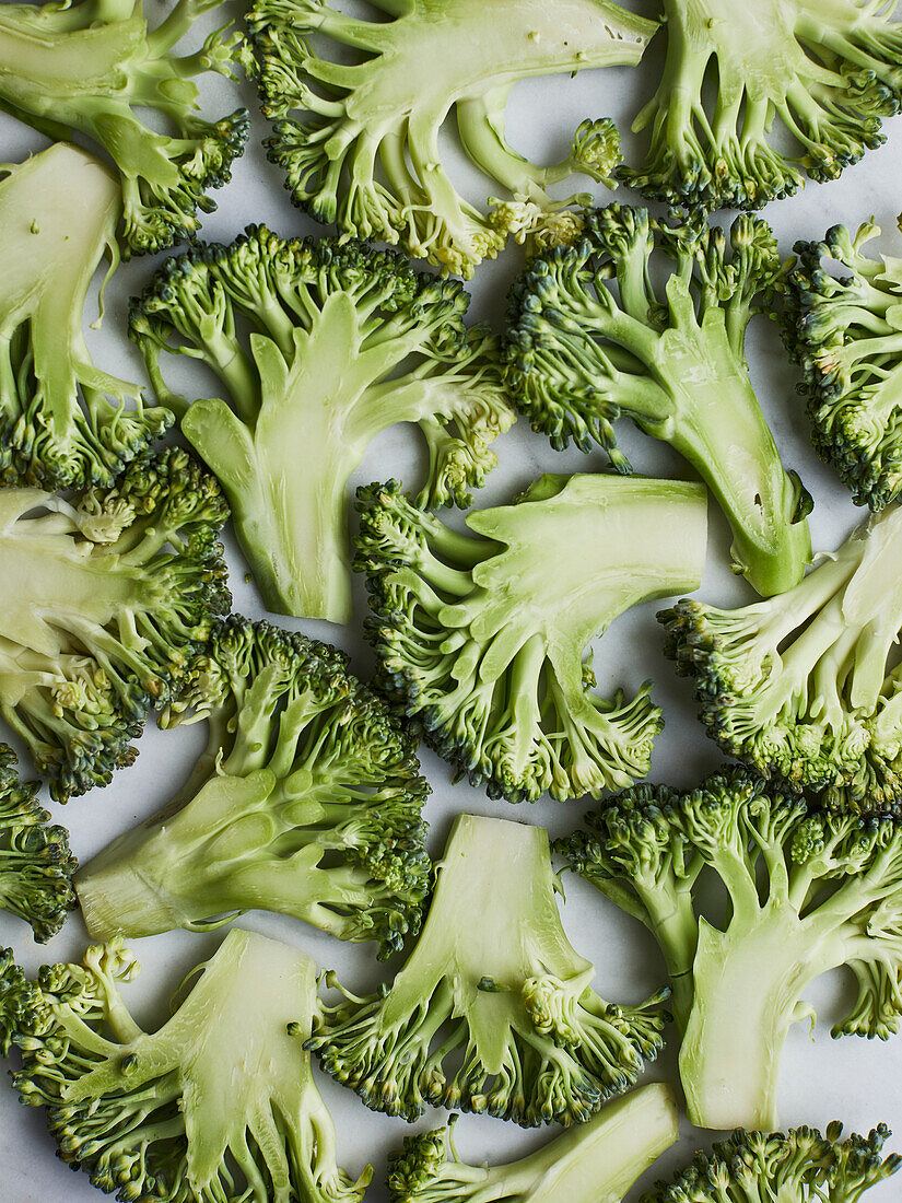 From above green broccoli stems placed on wooden background preparing to cook