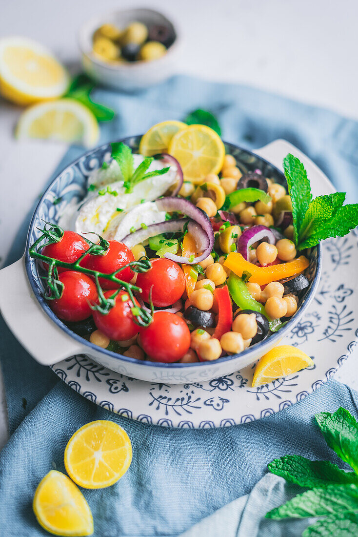 Köstlicher gesunder Salat mit Gemüse und Kräutern auf einem Teller mit unscharfem Hintergrund (von oben)