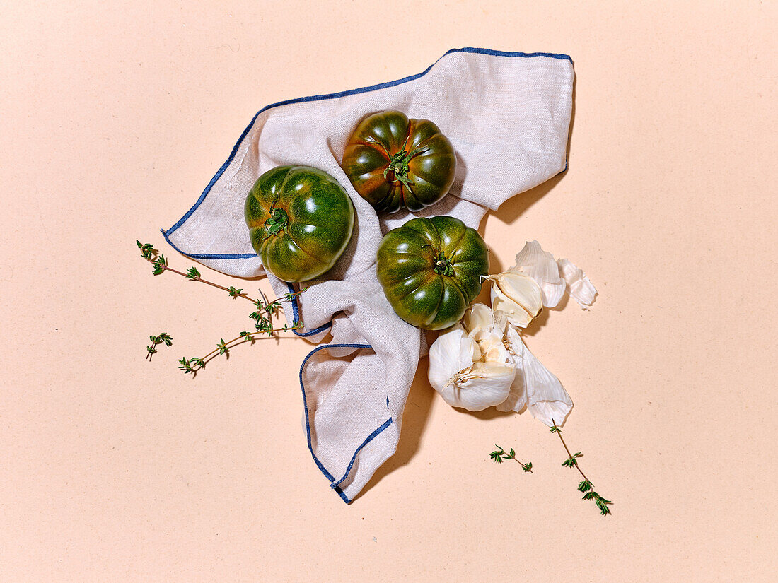 Grüne Tomaten in hellem Sonnenlicht, flach gelegt mit Kopierraum auf beigem Hintergrund