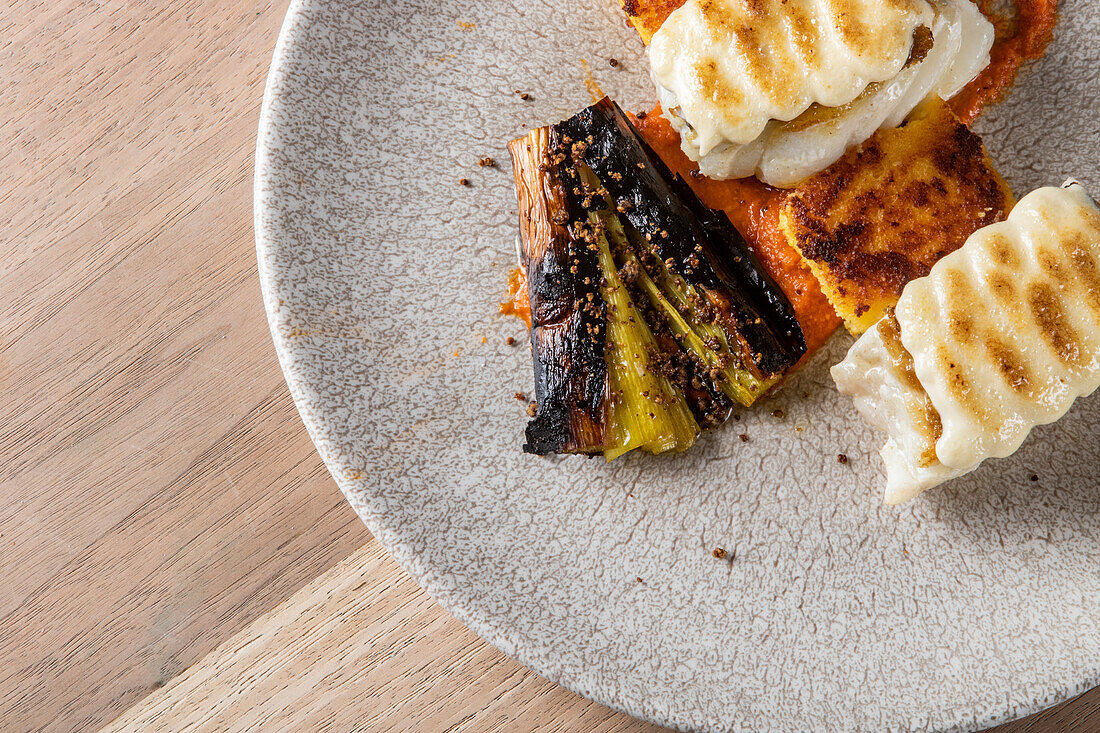 From above of tasty white fish fillets grilled with pepper and eggplant served on plate