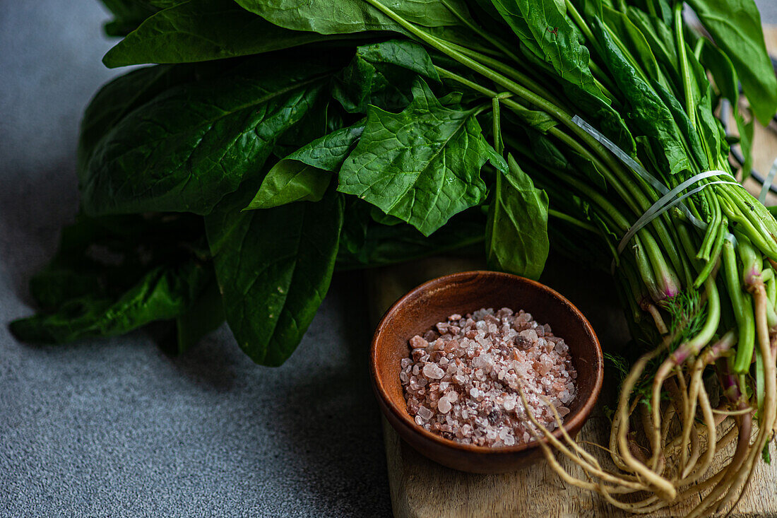 Fresh spinach leaves paired with aromatic spices in a wooden bowl set on a rustic backdrop ideal for creating a wholesome vegetable salad