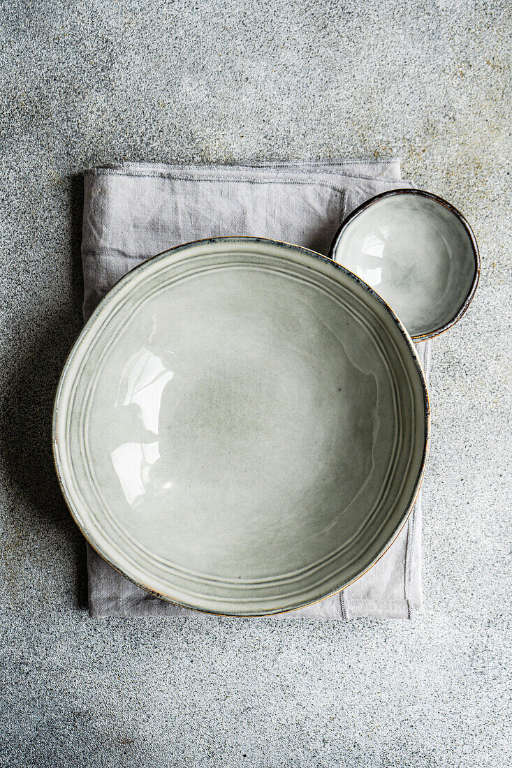 From top grey ceramic crockery set on a concrete background of the same color on top of a towel