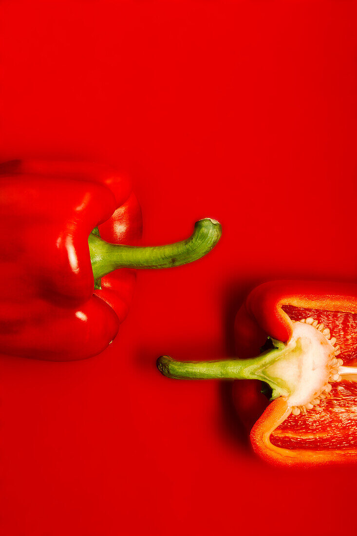 Draufsicht auf eine appetitliche Ernte frisch geschnittener roter Paprika auf roter Fläche