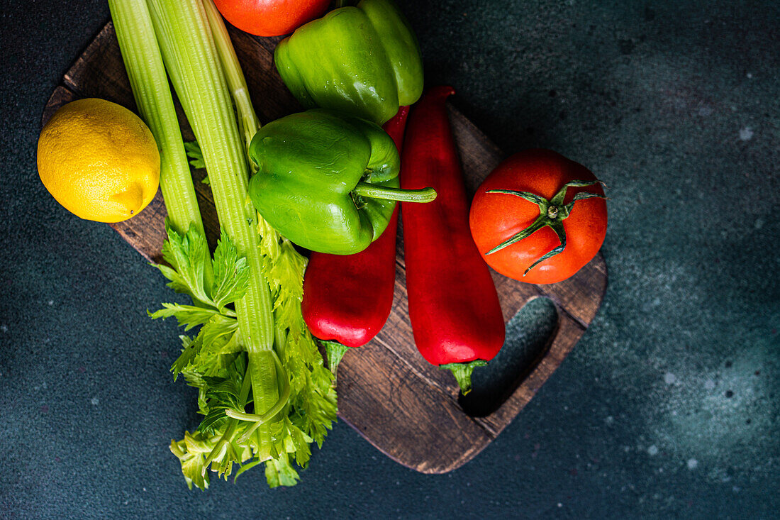 Draufsicht auf einen gesunden Gemüsesalat mit Zutaten auf einem Betontisch, bereit zum Kochen
