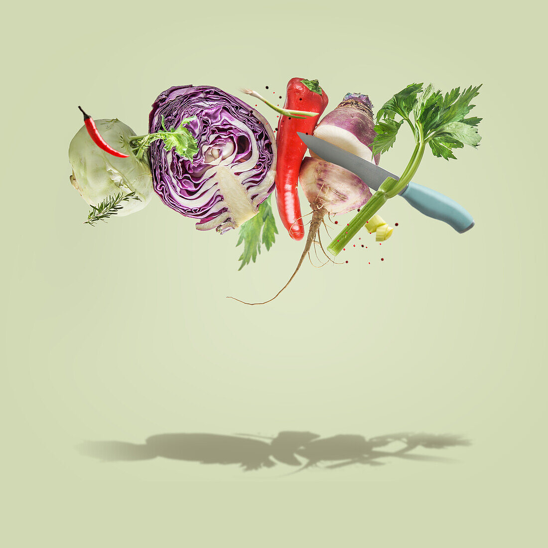Creative food levitation concept with flying various colorful vegetables and knife at pale green background. Healthy lifestyle