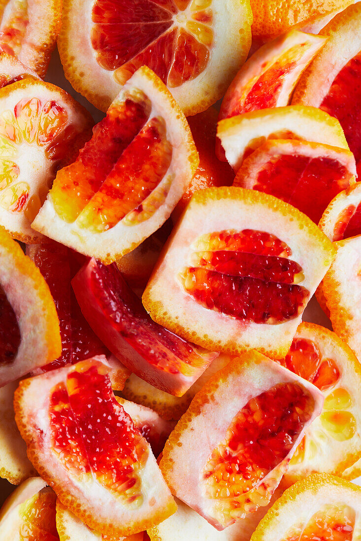 Full frame background of bright ripe pile of bloody orange peel slices on surface