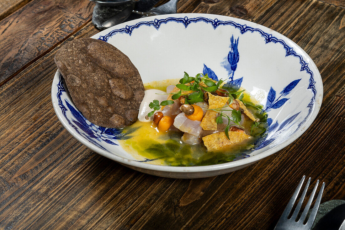 Ein köstliches Fusionsküche-Gericht mit einer Kombination aus lokalen und saisonalen Produkten aus einem Michelin-Stern-Restaurant in Zermatt, Schweiz, kunstvoll angerichtet mit leuchtenden Farben und Texturen