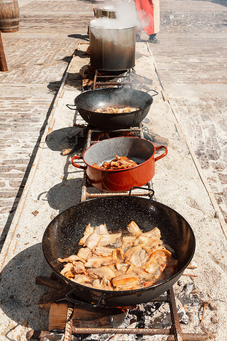 Foto einer Auslage mit mittelalterlichen Küchenköstlichkeiten. Eine Reihe von Pfannen gefüllt mit Lebensmitteln
