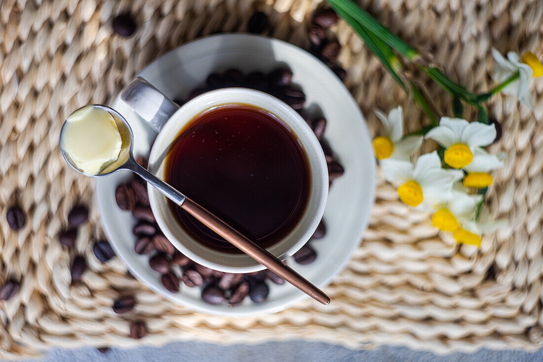 Tasse kugelsicherer Keto-Kaffee, serviert auf einem Betontisch an einem sonnigen Morgen