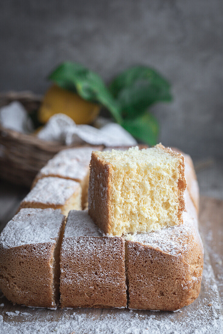 From above wooden board with Pasiego cake a typical cake from Catalonia in Spain sprinkled with sugar on rustic wooden table