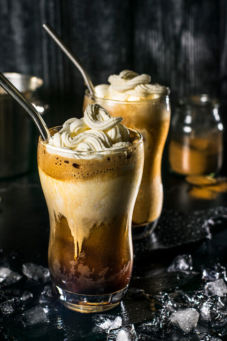 A tantalizing Greek frappe displayed with whipped cream on top, served in a tall glass surrounded by ice cubes, showcasing a perfect blend for a hot summer day