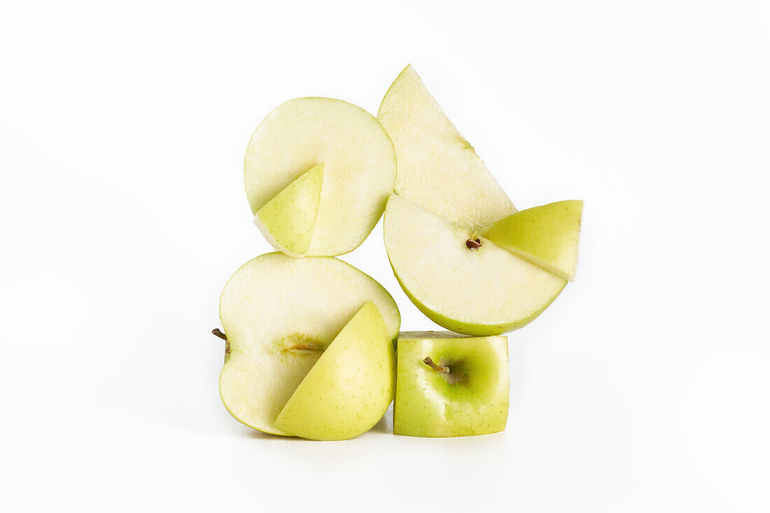 Deconstructed scene with beautifully arranged fresh healthy green apples with a white background