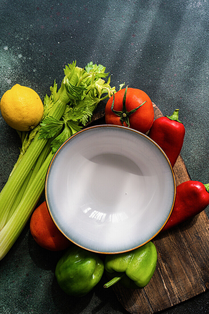 Draufsicht auf einen gesunden Gemüsesalat mit Zutaten auf einem Betontisch, bereit zum Kochen