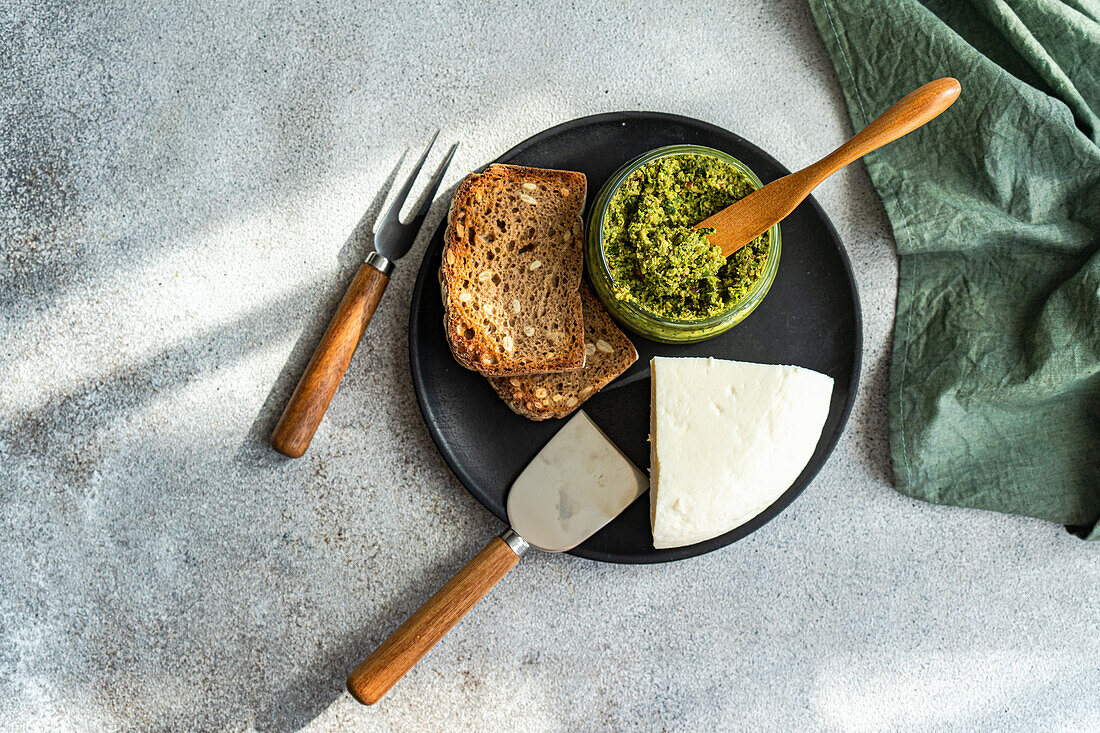 Draufsicht auf einen Teller mit köstlicher hausgemachter Brot-Käse-Sauce, serviert auf einem grauen Tisch mit Besteck und Serviette