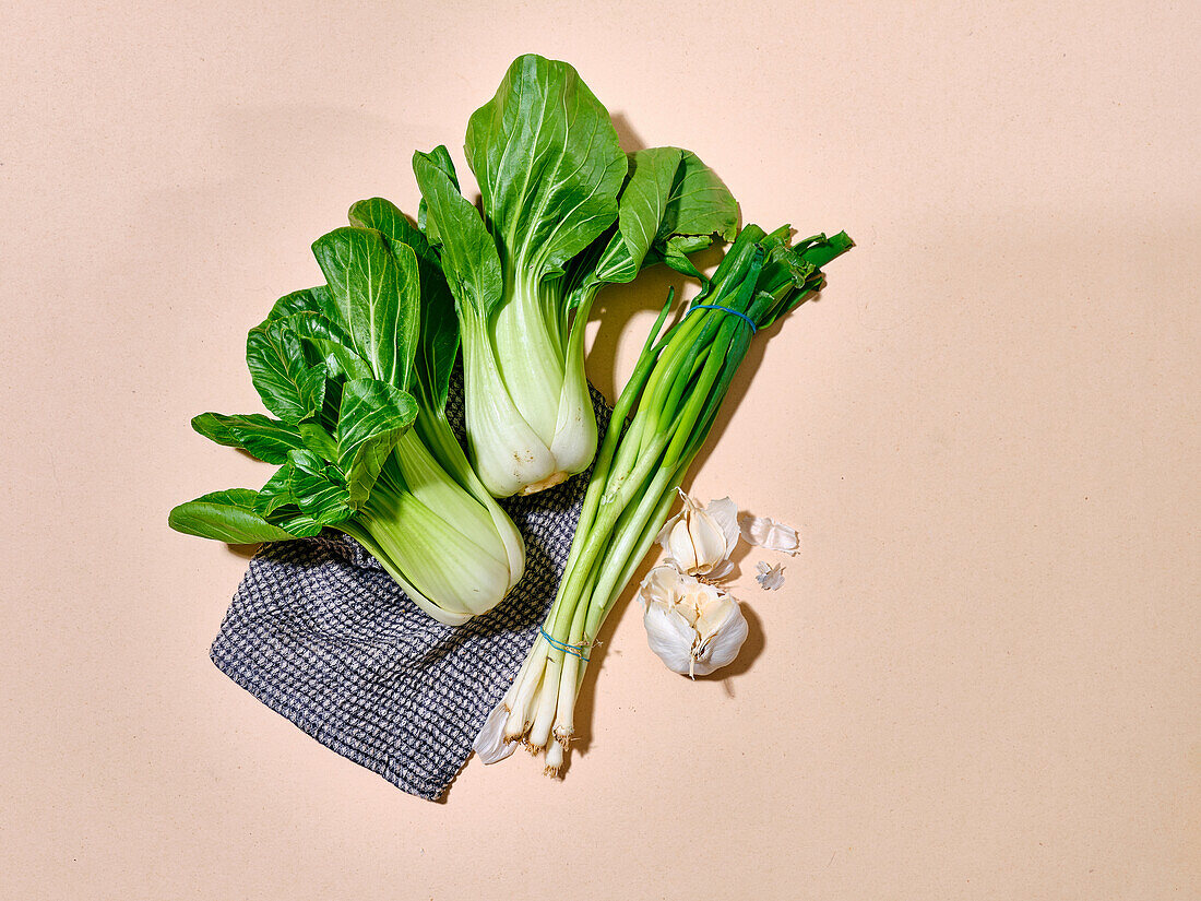 Bok choy cabbage in sunlight top view on warm beige background