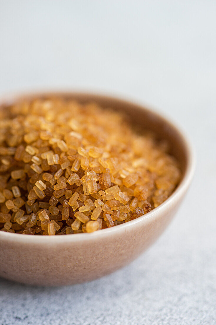 Organic brown textured sugar crystals in the bowl