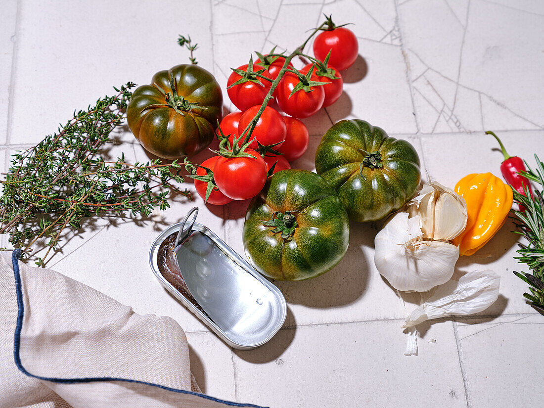 Flacher Teller mit frischem Gemüse auf gefliestem Hintergrund. Kochen gesundes Mittagessen mit verschiedenen Tomaten und Kräutern