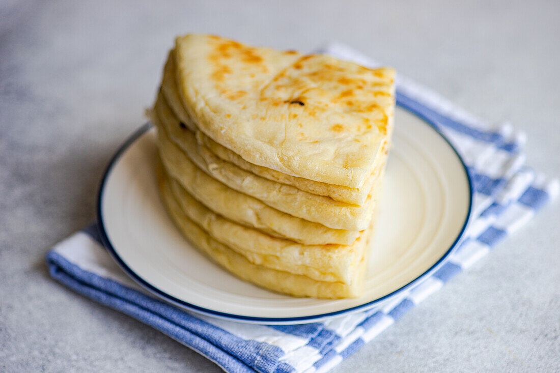 Fokus Traditionelles georgisches Gericht "Imeruli khachapuri" (Brotkuchen) mit Sulguni-Käse auf dem Teller