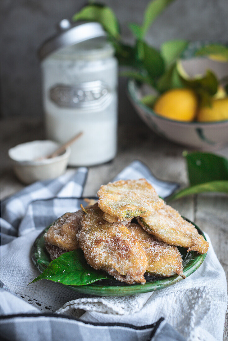 From above plate with paparajotes a typical dessert from Murcia in Spain made with lemon leaves and sprinkled with sugar on rustic wooden table