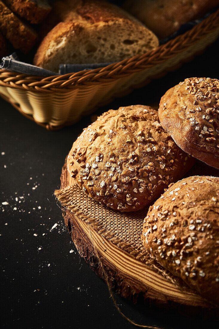 Delicious freshly baked bread with crispy crust sprinkled with mix of seeds and placed on wooden cutting board