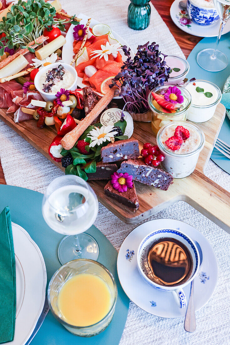 Elegant brunch spread featuring a variety of gourmet foods and drinks on a decorated table.