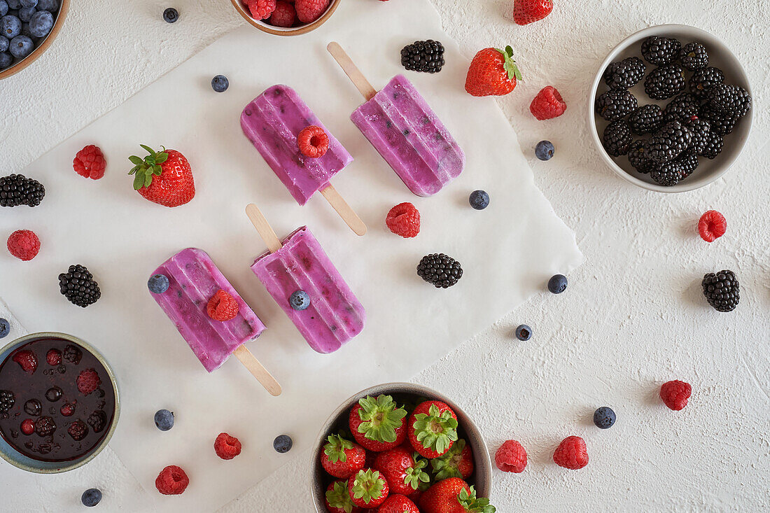 Top view of homemade organic vegan protein ice cream placed on white surface near bowls with different fresh fruits