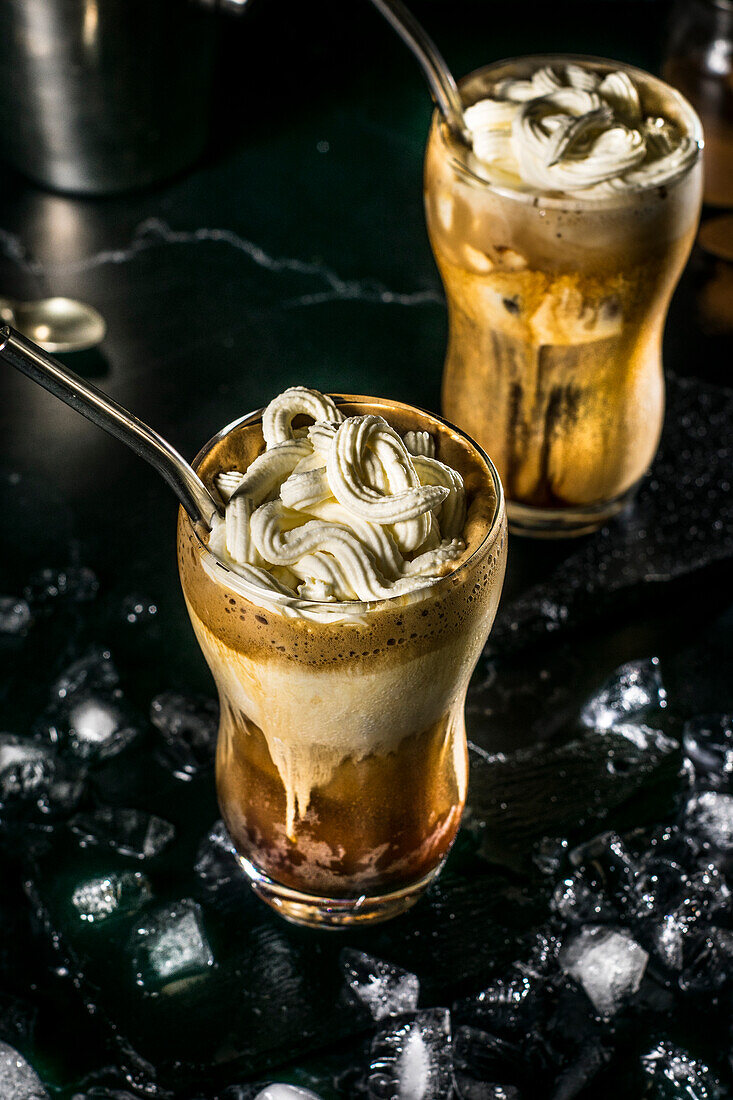 A fully prepared Greek frappe in a tall glass, crowned with a generous amount of whipped cream, ready to be enjoyed on a sweltering day