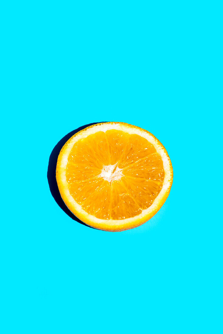 Closeup von Scheibe von frischen orangefarbenen Früchten isoliert auf blauem Hintergrund mit Kopie Raum