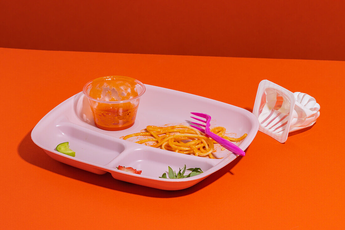 Von oben Reste von appetitlichen Spaghetti mit Gabel Tomatensauce Schüssel Scheiben von Gurken und Erdbeeren serviert zum Mittagessen mit leeren Gelee Tasse