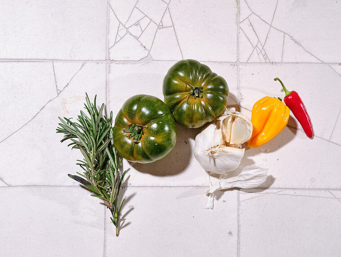 Flacher Teller mit frischem Gemüse auf gefliestem Hintergrund. Kochen gesundes Mittagessen mit verschiedenen Tomaten und Kräutern